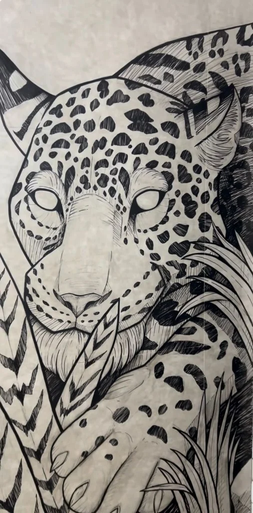 Arte da onça-pintada na parede do estúdio Xandos Tattoo